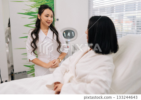 Portrait of young Asian cosmetologist discussing treatment options with female client during professional consultation at modern beauty clinic, providing expert skincare advice and aesthetic services. Portrait of young Asian cosmetologist discussing treatment options with female client during professional consultation at modern beauty clinic, providing expert skincare advice and aesthetic services. 133244643