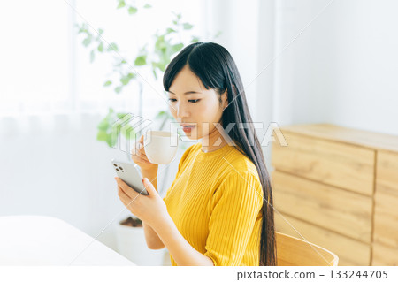 看她的智能手機的一個少婦，當喝咖啡時 133244705