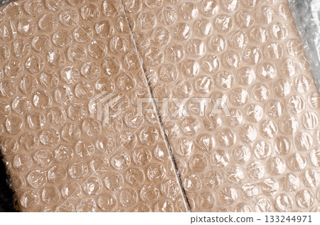 Cardboard box with bubble wrap. The concept of packaging parcels with fragile cargo. 133244971