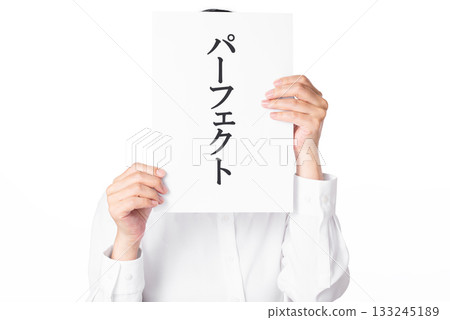一個身穿白襯衫的人雙手拿著一張紙，紙上寫著「完美」二字。 133245189