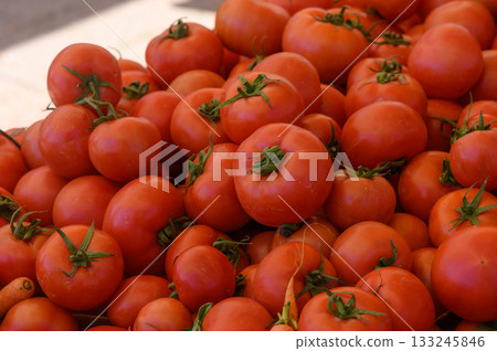 Vibrant market display of ripe tomatoes under warm sunlight Vibrant market display of ripe tomatoes under warm sunlight 133245846