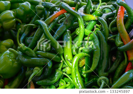 Vibrant assortment of fresh green and red chilies at a bustling farmers market in mid-afternoon light Vibrant assortment of fresh green and red chilies at a bustling farmers market in mid-afternoon light 133245897