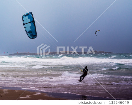 Kite surfer riding waves. Kiteboarding sport. 133246049