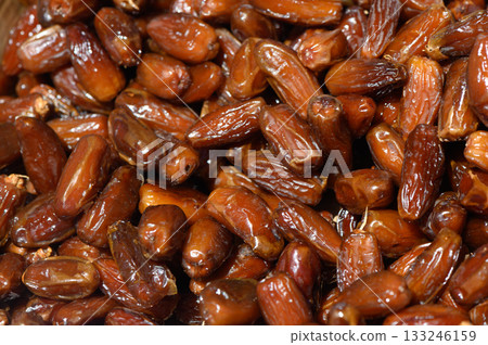Freshly harvested dates beautifully arranged in a wooden bowl at a local market during the golden hour Freshly harvested dates beautifully arranged in a wooden bowl at a local market during the golden hour 133246159