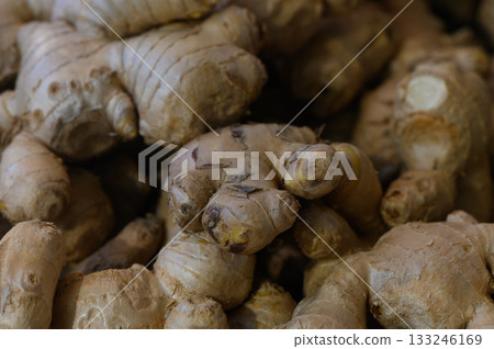 Fresh ginger roots piled together at a local market showcasing nature's flavor and health benefits Fresh ginger roots piled together at a local market showcasing nature's flavor and health benefits 133246169