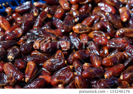 Dried dates piled together in a vibrant marketplace during the afternoon sun 133246176