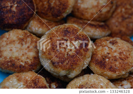 Golden brown patties sizzling in a pan on a sunny afternoon Golden brown patties sizzling in a pan on a sunny afternoon 133246328