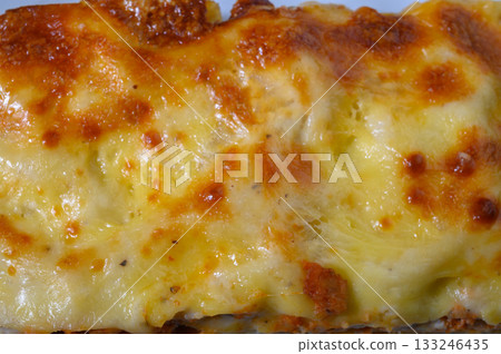 Golden-brown baked dish with bubbling cheese, fresh from the oven, perfect for a comforting meal experience Golden-brown baked dish with bubbling cheese, fresh from the oven, perfect for a comforting meal experience 133246435