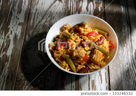 Vibrant rice bowl filled with vegetables and chicken in a cozy rustic setting Vibrant rice bowl filled with vegetables and chicken in a cozy rustic setting 133246532
