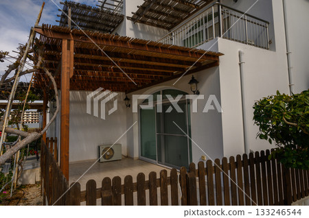 Charming outdoor patio adorned with wooden trellis in a serene garden setting bathed in soft afternoon light Charming outdoor patio adorned with wooden trellis in a serene garden setting bathed in soft afternoon light 133246544