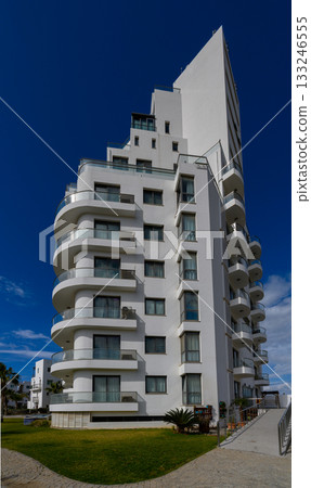 Modern architecture shines under a clear blue sky at a coastal location during a sunny afternoon 133246555
