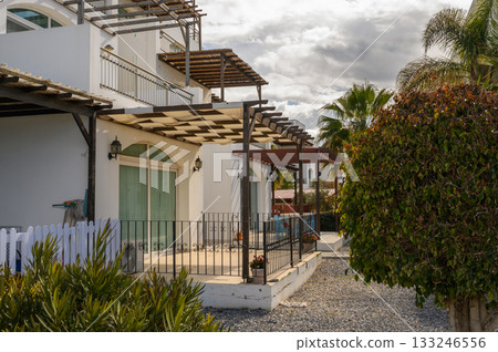 Cozy seaside villas surrounded by lush greenery on a sunny afternoon 133246556