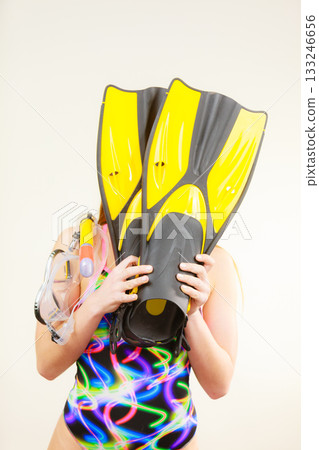 Woman covering her face with flippers having fun Woman covering her face with flippers having fun 133246656