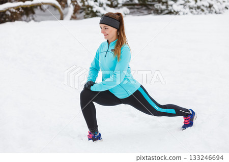 Winter workout. Girl wearing sportswear, stretching exercises. Winter workout. Girl wearing sportswear, stretching exercises. 133246694