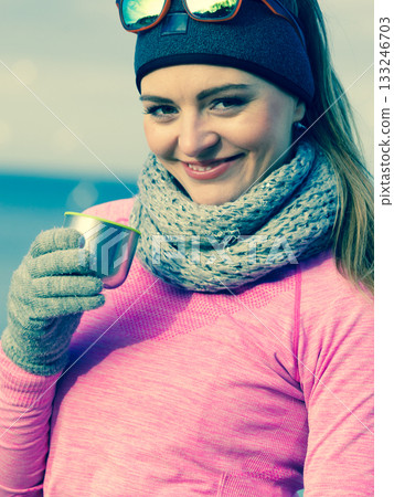 Fit woman in cold day warming up drink tea 133246703