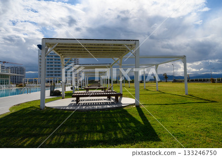 Relaxing afternoon at a serene outdoor space with shaded benches and a beautiful backdrop 133246750