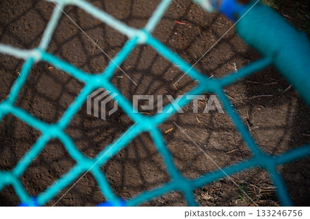Catching light through a colorful net in a sunlit outdoor playground setting 133246756