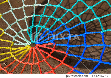 Intricate colorful web patterns cast shadows on a sunlit surface during midday moments of creativity Intricate colorful web patterns cast shadows on a sunlit surface during midday moments of creativity 133246757