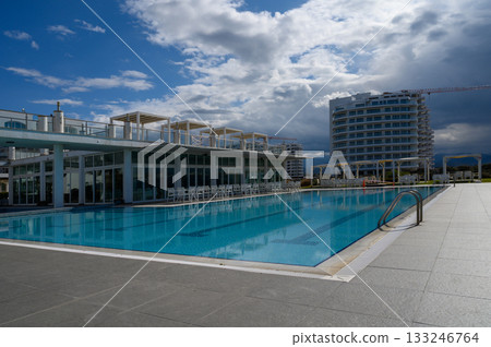 Tranquil afternoon by the serene poolside under a soothing cloudy sky in a modern resort setting 133246764