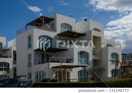 Modern coastal architecture showcases elegance under a vibrant sky in a serene seaside neighborhood 133246777