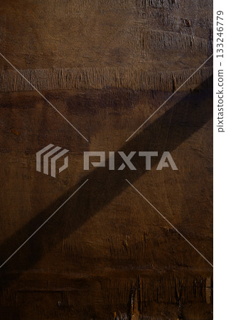 Soft shadows dance on textured wood under warm afternoon light creating a serene atmosphere 133246779