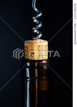 Corkscrew twists gracefully as it opens a fine bottle of wine at an elegant gathering Corkscrew twists gracefully as it opens a fine bottle of wine at an elegant gathering 133246876