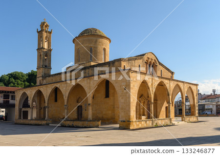 Majestic stone architecture stands in a sunlit plaza surrounded by trees and vibrant buildings Majestic stone architecture stands in a sunlit plaza surrounded by trees and vibrant buildings 133246877