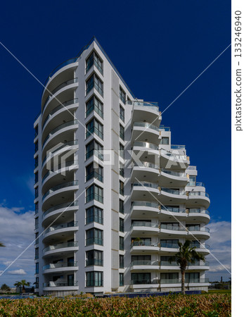 Contemporary residential building against a clear blue sky in a vibrant urban setting Contemporary residential building against a clear blue sky in a vibrant urban setting 133246940