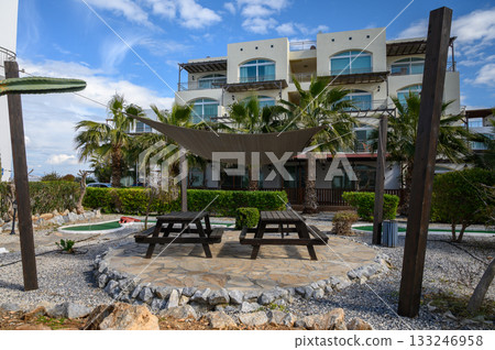 Relaxation spot with picnic tables and shade in a tropical garden setting 133246958