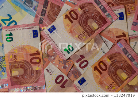 Colorful collection of euro banknotes spread across a surface, showcasing intricate designs and vivid hues 133247019