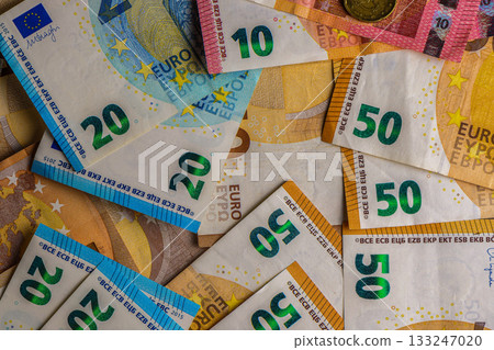 Currency exchange with various Euro denominations laid out on a wooden surface at a financial center 133247020