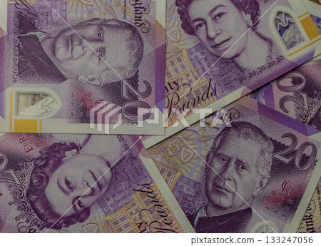 Explore the intricacies of British currency featuring portraits of royalty and vibrant designs in close-up view 133247056
