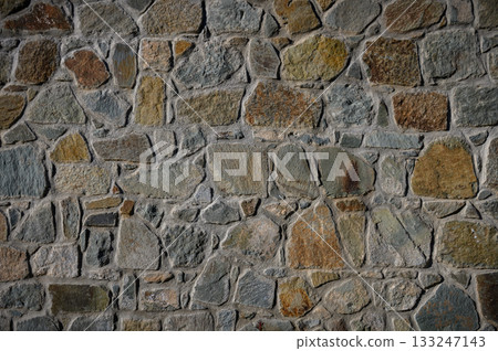 Textured stone wall showcasing earthy tones and natural patterns in a rustic setting Textured stone wall showcasing earthy tones and natural patterns in a rustic setting 133247143