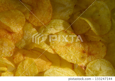 Crispy potato chips arranged delightfully in a satisfying yellow embrace on a bright sunny day 133247144