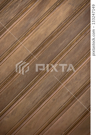 Wooden panels arranged in a diagonal pattern create a rustic charm in a cozy interior space 133247149