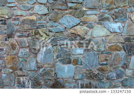 Colorful stone wall composed of various textured rocks enhancing architectural beauty Colorful stone wall composed of various textured rocks enhancing architectural beauty 133247150