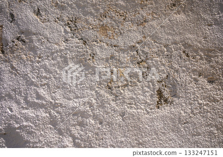 Textured surface of aged wall revealing intricate patterns and natural hues in soft lighting 133247151