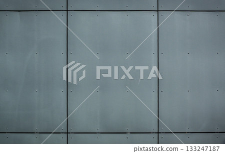Industrial gray wall with sleek metal panels reflecting modern architectural style Industrial gray wall with sleek metal panels reflecting modern architectural style 133247187