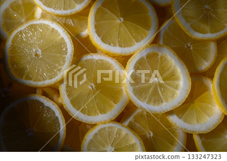 Brightly sliced lemons create a vibrant pattern in natural light during a summer afternoon Brightly sliced lemons create a vibrant pattern in natural light during a summer afternoon 133247323