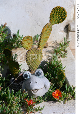 Whimsical cactus frog garden sculpture brightens a sunny outdoor space with vibrant greenery Whimsical cactus frog garden sculpture brightens a sunny outdoor space with vibrant greenery 133247375