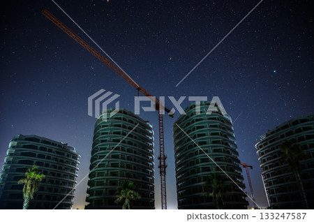 Nightfall unveils a skyline of modern architecture under a starry sky 133247587