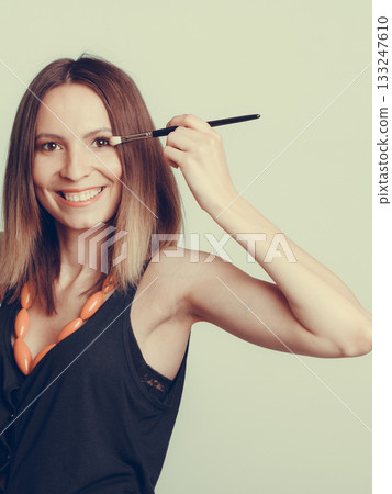 Woman stylist applying eyeshadow with brush. 133247610