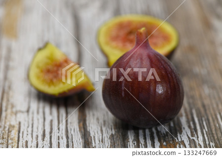 Fresh ripe fig on rustic textured wooden background Fresh ripe fig on rustic textured wooden background 133247669