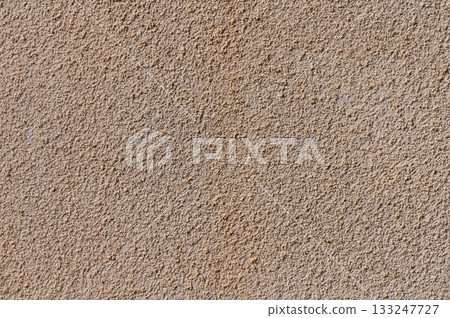 Textured surface displaying sandy hues and subtle patterns against a neutral backdrop at midday light Textured surface displaying sandy hues and subtle patterns against a neutral backdrop at midday light 133247727