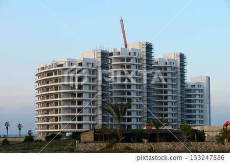 Modern residential building under construction near the coast at sunset 133247886