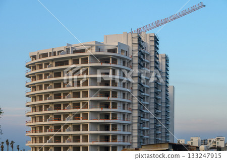 Urban construction rising against a clear sky in the evening light Urban construction rising against a clear sky in the evening light 133247915