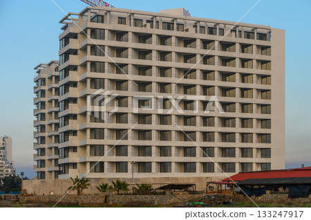 Modern architecture stands tall against a clear blue sky in a vibrant cityscape 133247917