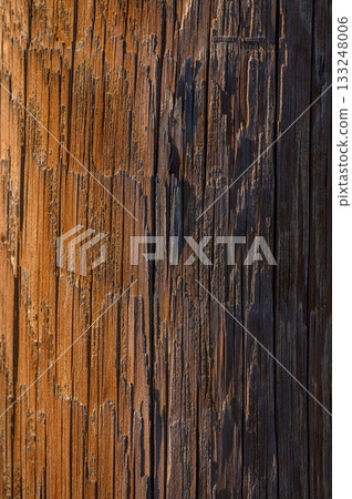 Weathered wooden pole showcasing nature's artistry at sunset in a tranquil rural setting Weathered wooden pole showcasing nature's artistry at sunset in a tranquil rural setting 133248006