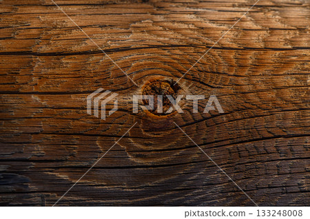 Warm tones of aged wood reveal natural patterns in a rustic setting during golden hour light 133248008