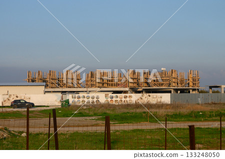 Construction site bustling with activity under a clear blue sky in an urban area during daylight hours 133248050